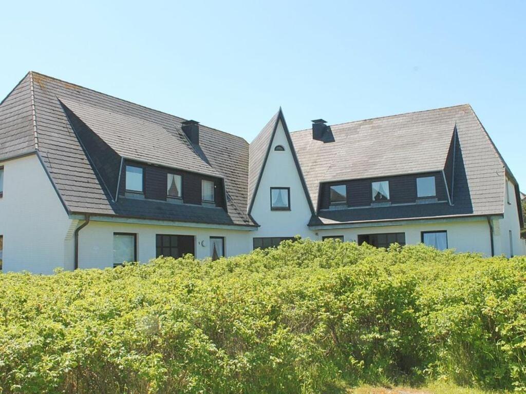 a large white house with a gambrel roof at Rüm Hart I - Apartment 9A in Hörnum