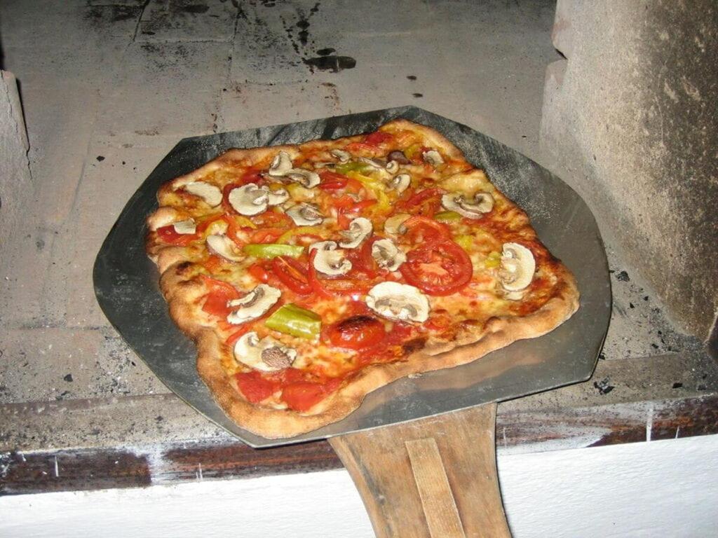 a pizza with mushrooms and peppers on a pan at Oberprill Modern retreat 