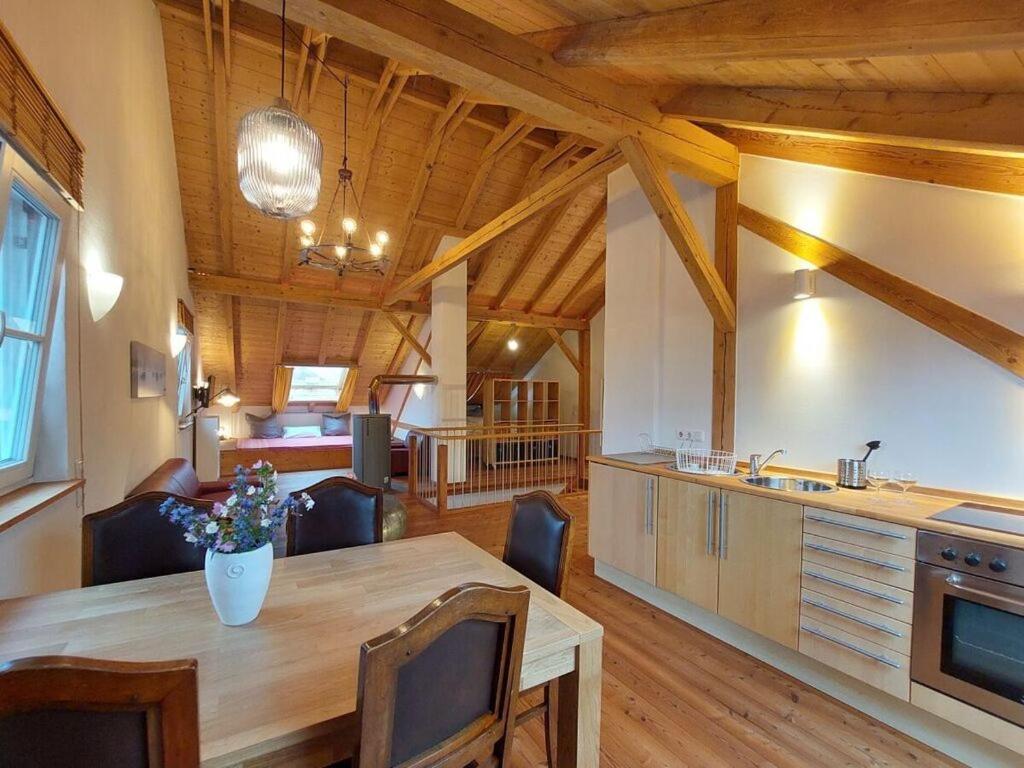 eine Küche und ein Wohnzimmer mit Holzdecke in der Unterkunft Schleichhof Ammersee in Dießen am Ammersee