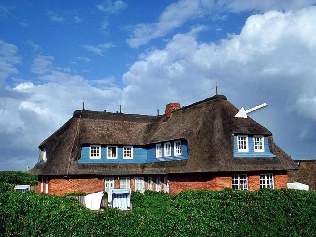 a large house with a thatched roof on a hill at Haus Ruusenhoog - Apartment 5 in Rantum