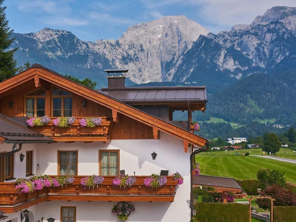 a house with flowers on the balcony with mountains in the background at Hochkalter - Reich family in Schönau am Königssee