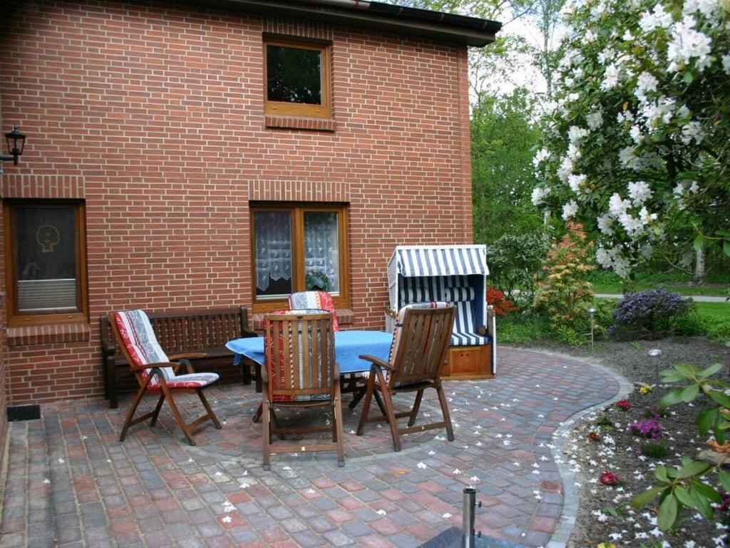 um pátio com cadeiras e uma mesa em frente a um edifício de tijolos em Elke Lüthje Modern retreat em Hochdonn