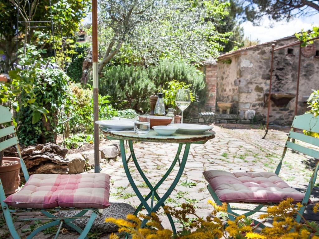 einen Tisch und zwei Stühle in einem Garten in der Unterkunft Casa La Fonte - Olivastra in Seggiano