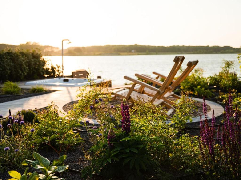 un par de sillas de madera sentadas junto a un lago en Oceanhouse Modern Retreat en Den Oever