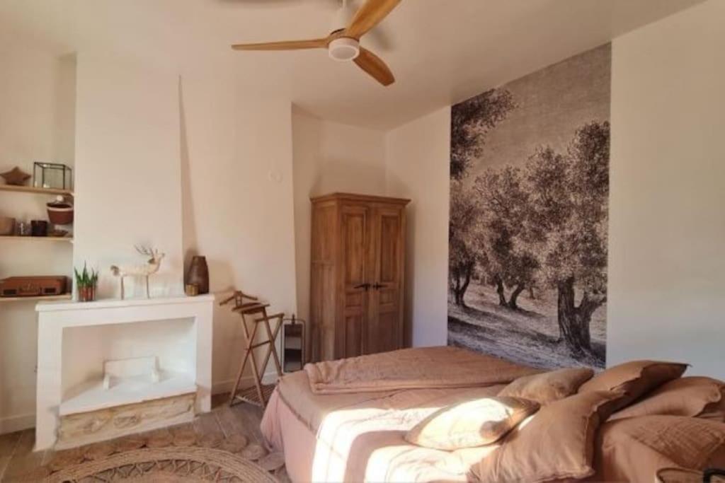 - une chambre avec un lit et une peinture murale dans l'établissement Appartement avec terrasse en centre-ville, à LʼIsle-sur-la-Sorgue