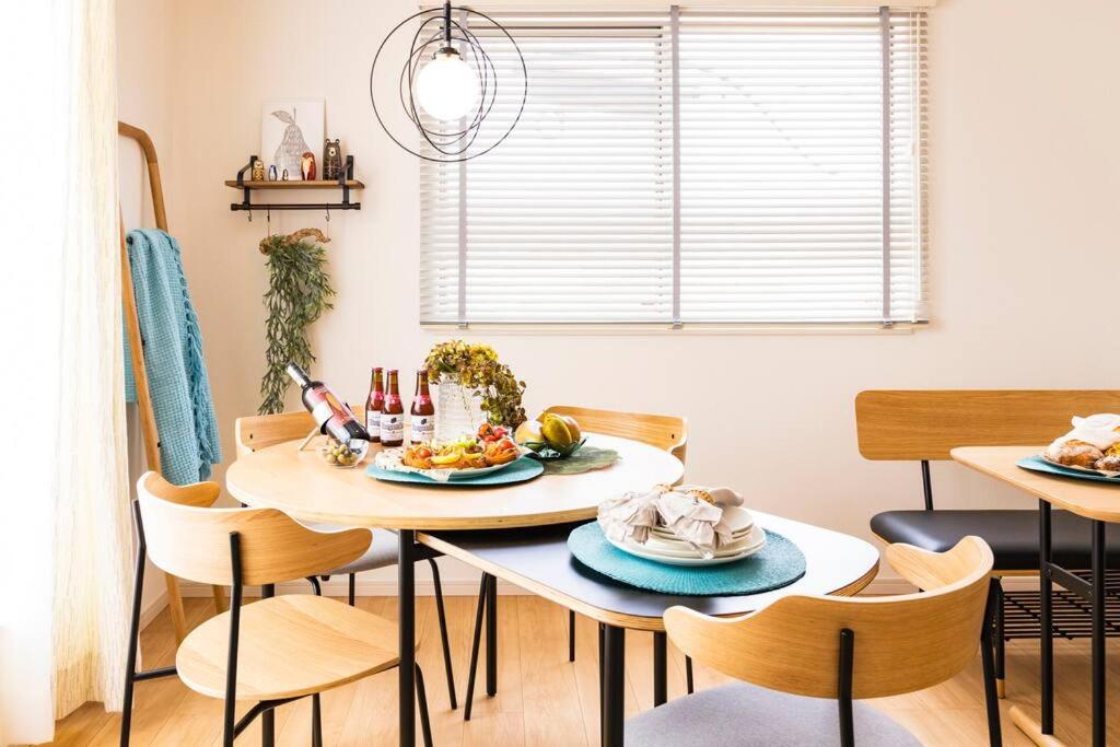 a dining room with a table and chairs with food on it at 海まで徒歩30秒！人気の北谷エリアでまるまる一棟ゆったり貸し切り！ in Hamakawa
