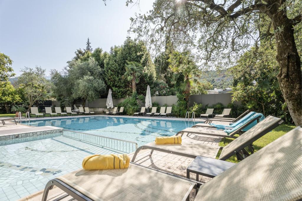 een zwembad met ligstoelen en stoelen bij Hotel Gabry in Riva del Garda