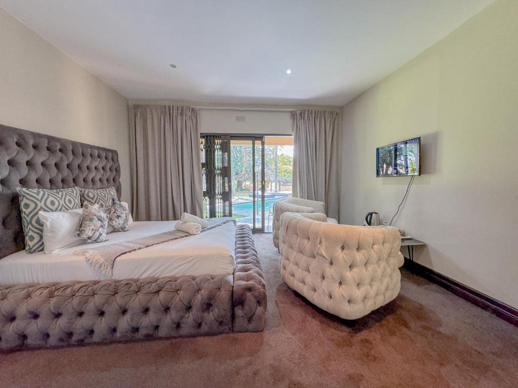 a bedroom with a large bed and a chair at Fullbliss Guesthouse in Johannesburg
