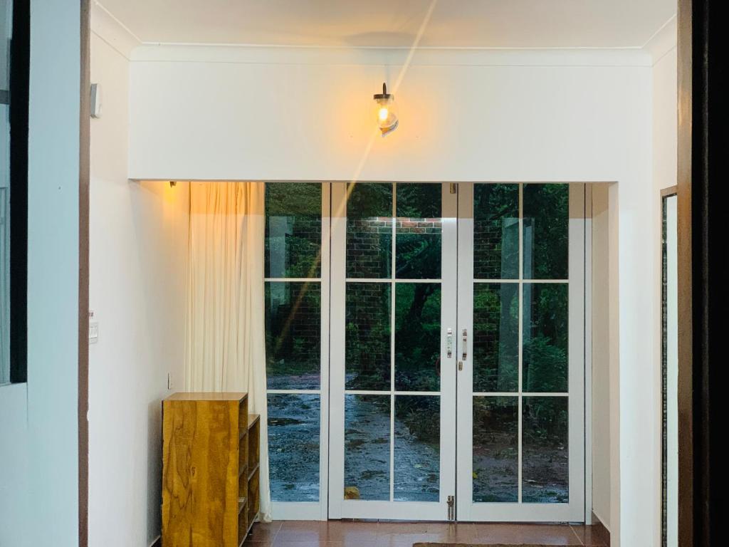 a large glass door in a room with a window at Vythiriii county side homestay in Vythiri