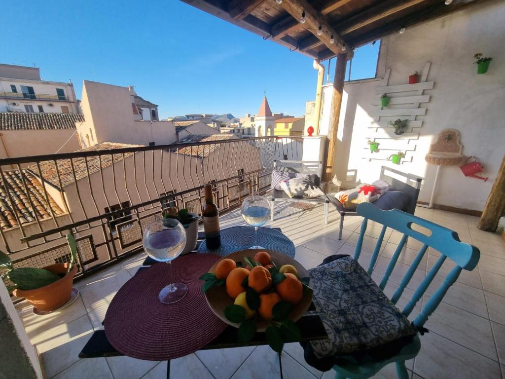 - une table avec des verres à vin et un bol de fruits sur le balcon dans l'établissement La Gorgone, à Casteldaccia