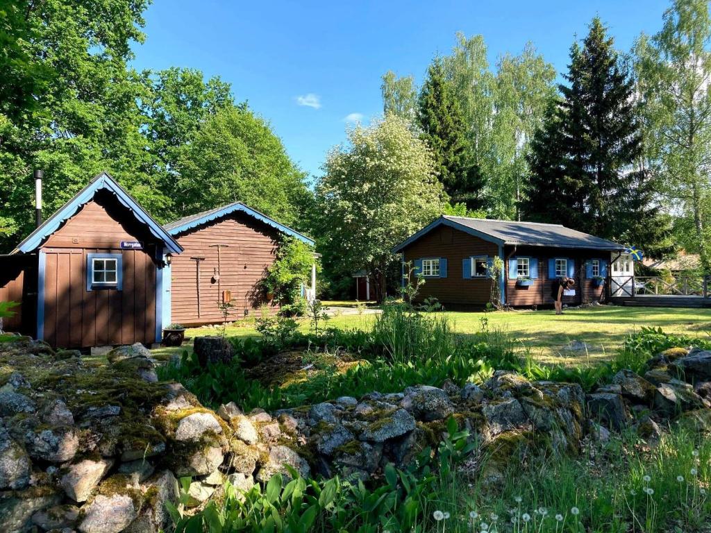 two barns and a house in a yard at Holiday home ODENSBACKEN IV in Stora Mellösa