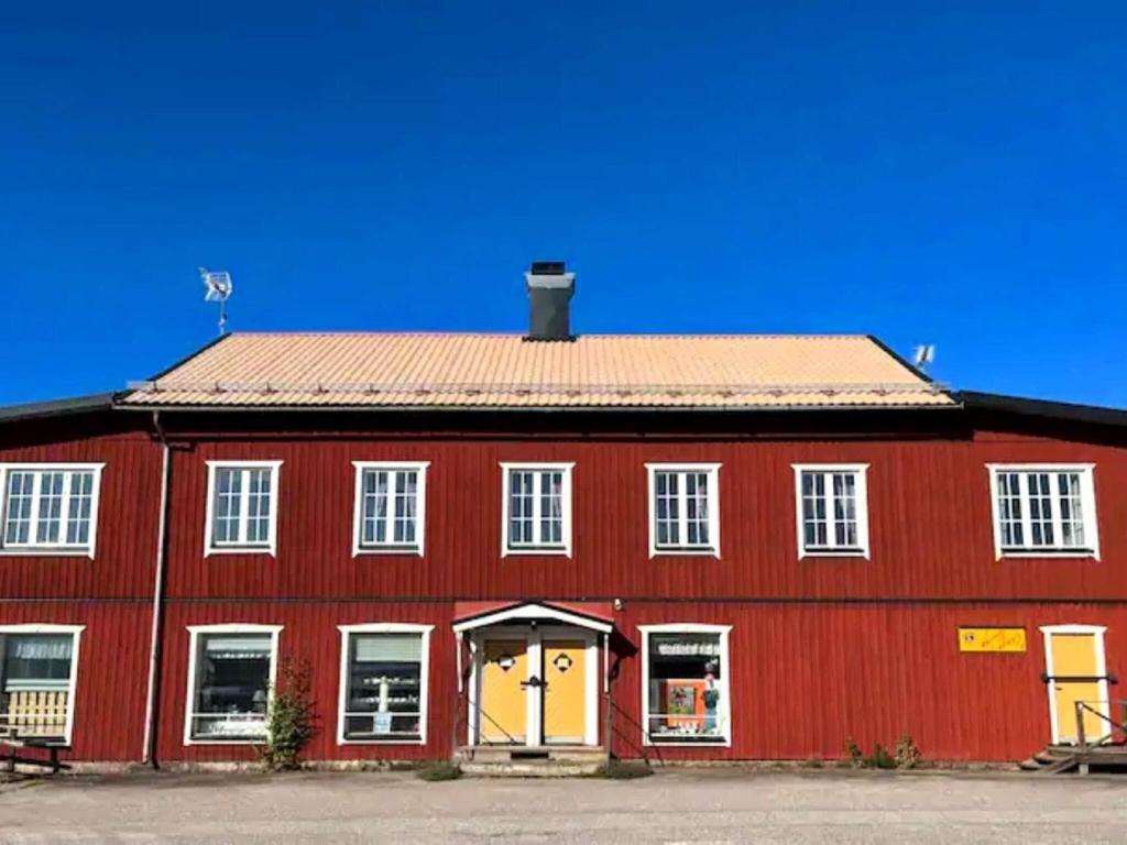 a red barn with a red roof and white windows at Holiday home FREDRIKSBERG III in Fredriksberg