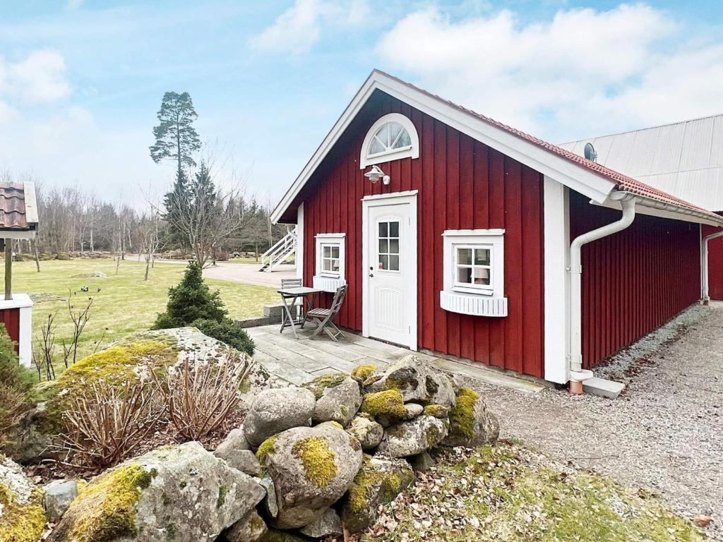 un edificio rojo y blanco con un montón de rocas en Holiday home VÄXJÖ II en Växjö