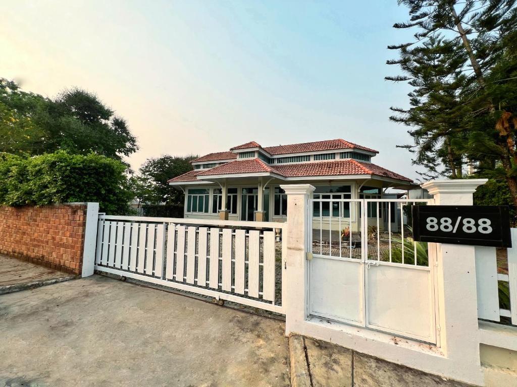 a white fence in front of a house at Villa88 in San Kamphaeng