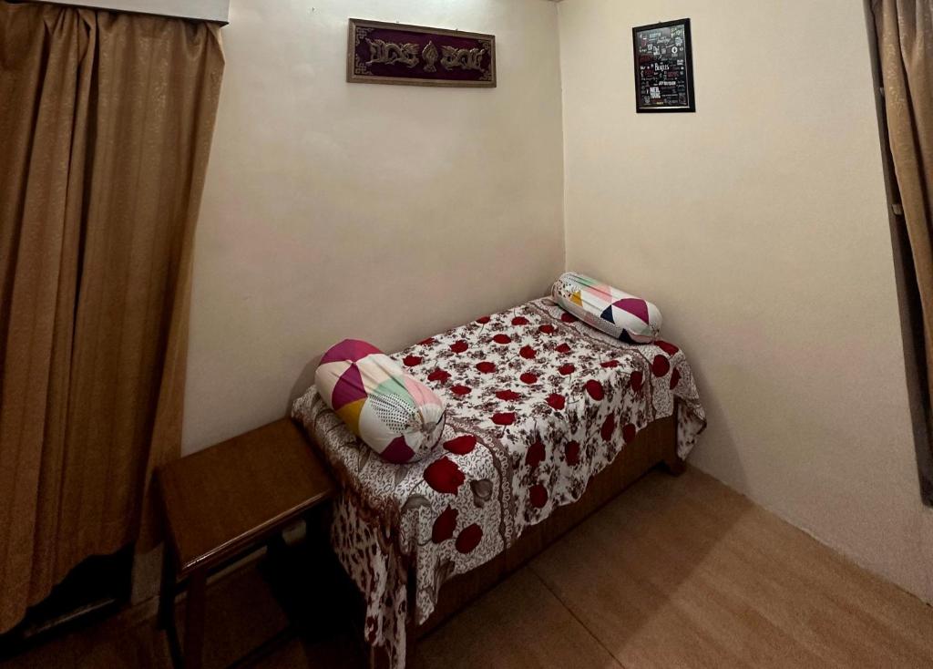 穆索里Landour Vintage Homestay的小房间设有一张带桌子和枕头的床