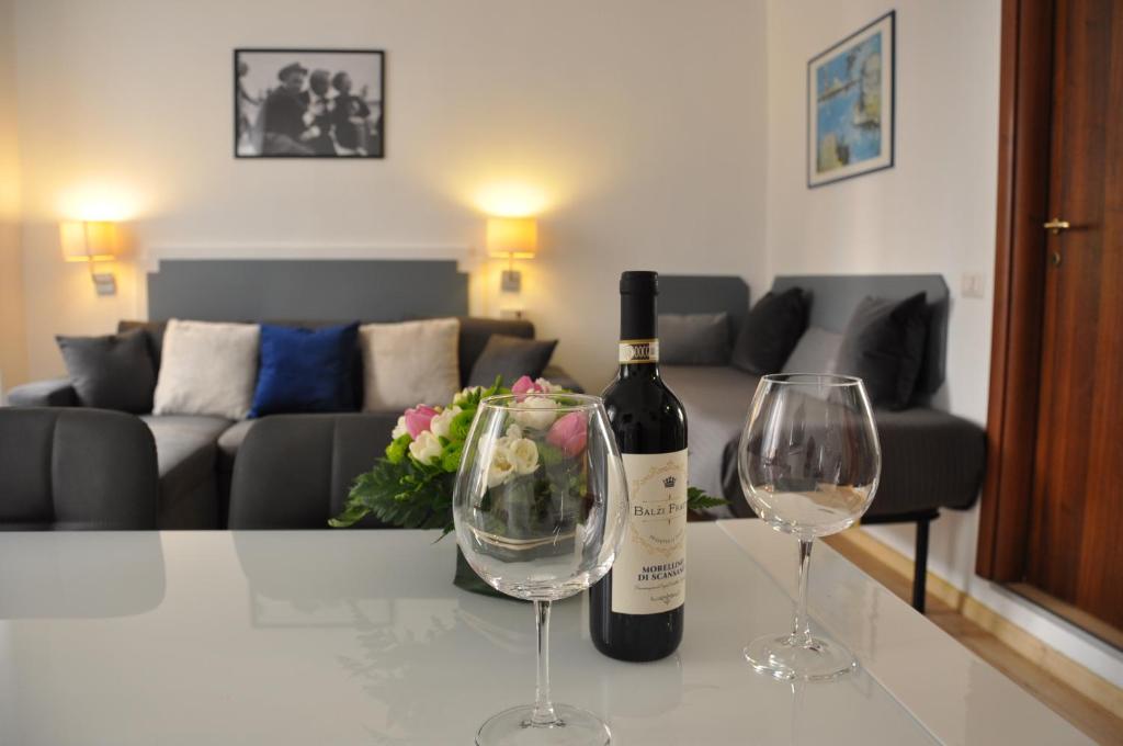 Una botella de vino y dos copas de vino en una mesa en Colosseo studios, en Roma