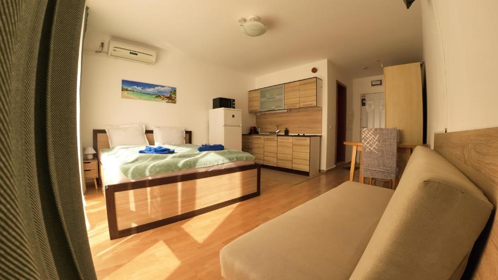 a bedroom with a bed and a desk in a room at William's fourth pretty studio-Crown Fort Noks in Sveti Vlas