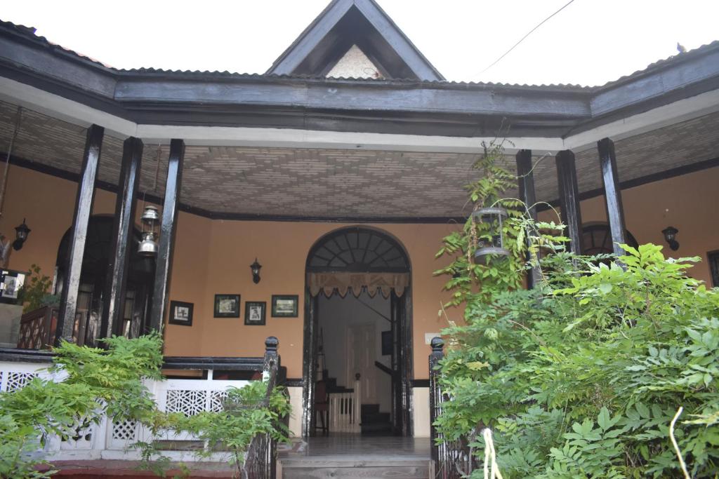 une vieille maison avec une porte et quelques plantes dans l'établissement Dak Hermitage, à Srinagar