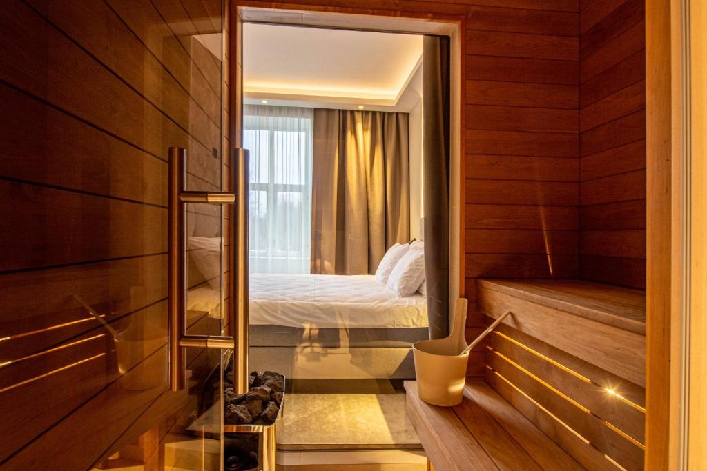 Cette petite chambre comprend un lit et un miroir. dans l'établissement City Panorama with SAUNA, à Tartu