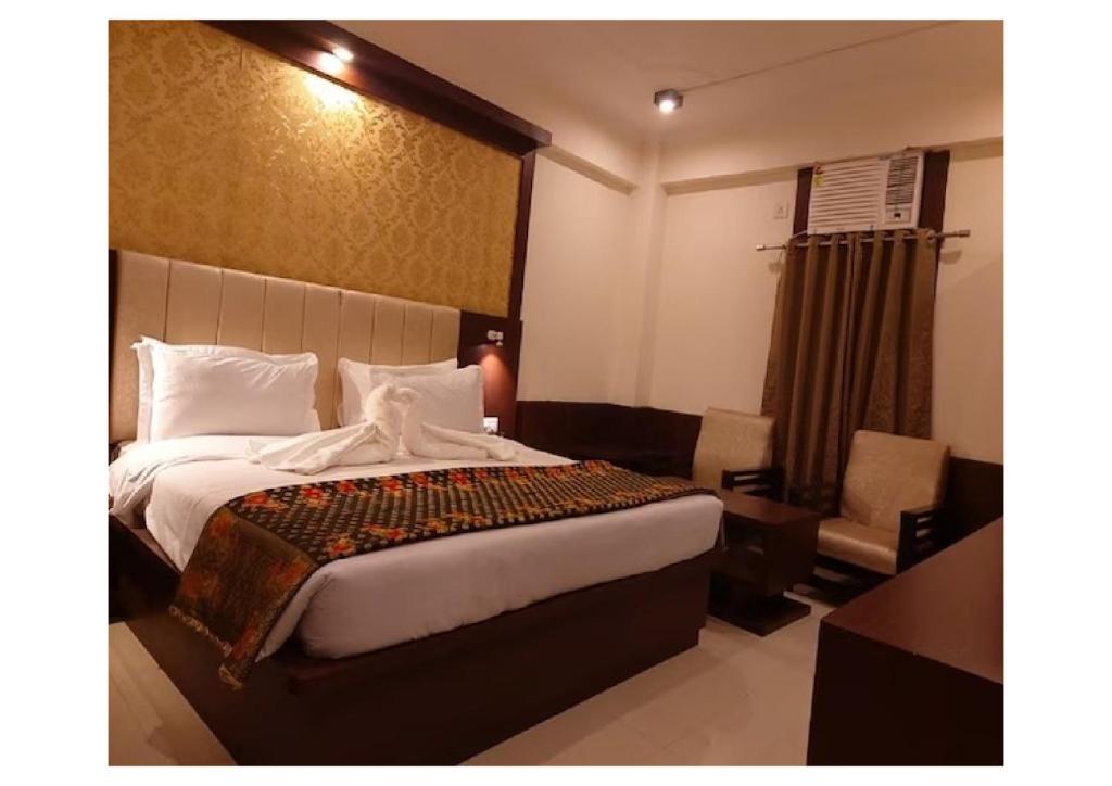 Postel nebo postele na pokoji v ubytování Hotel Ganga Aatitheyam