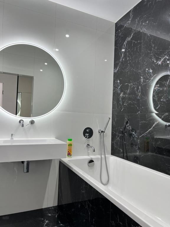 a white bathroom with a sink and a mirror at ВІП Апартаменти в районі автовокзалу,ЖК Арена,ПОБЛИЗУ ОБЛАСНОІ ЛІКАРНІ in Rivne