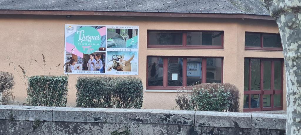 a house with posters on the side of it at Le Porteur de Glace Classé 2 étoiles in Aulus-les-Bains