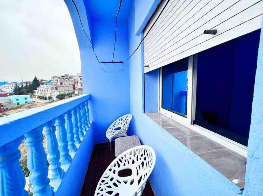 uma varanda com 2 cadeiras e uma parede azul em Silius em Chefchaouen
