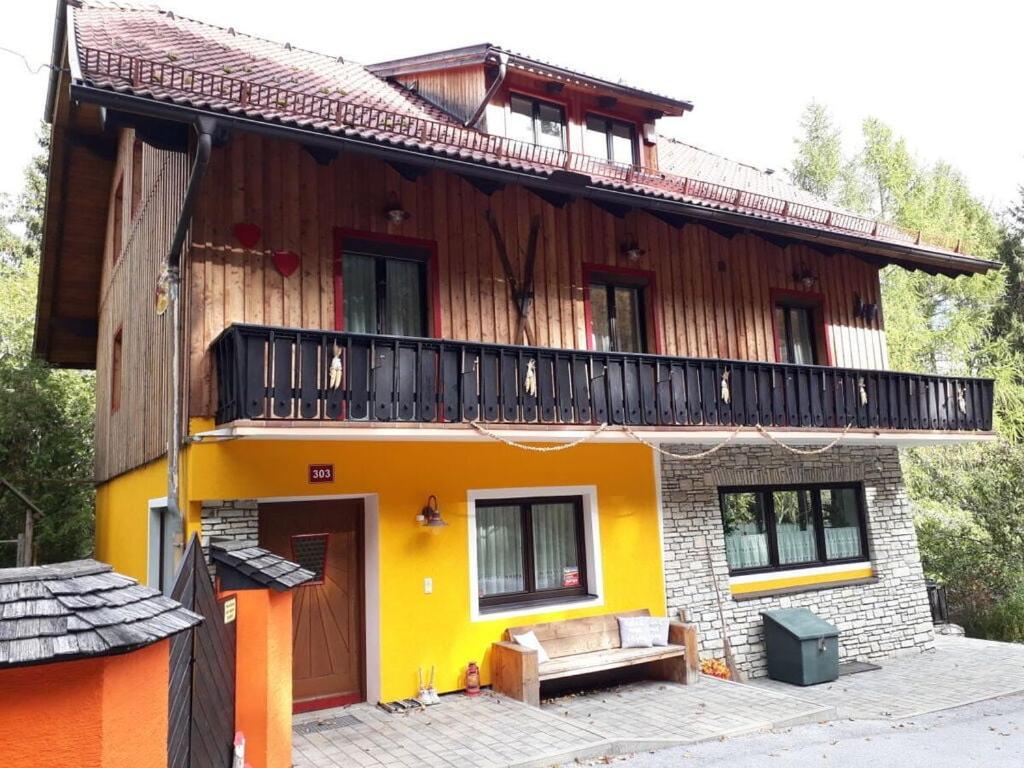 a yellow house with a balcony on top of it at Holiday home-Aloisia 