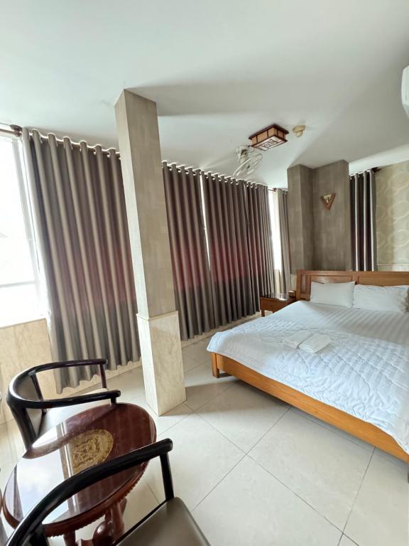 - une chambre avec un lit et une chaise dans l'établissement Khách sạn Sài Gòn, à Hô-Chi-Minh-Ville