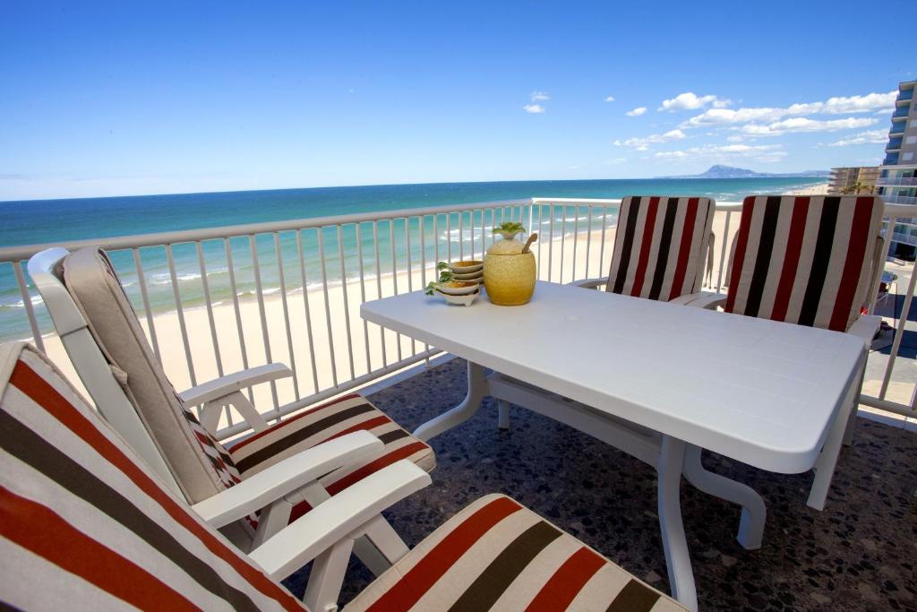 una mesa y sillas en un balcón con vistas a la playa en Apartamento Bellavista, en Daimuz