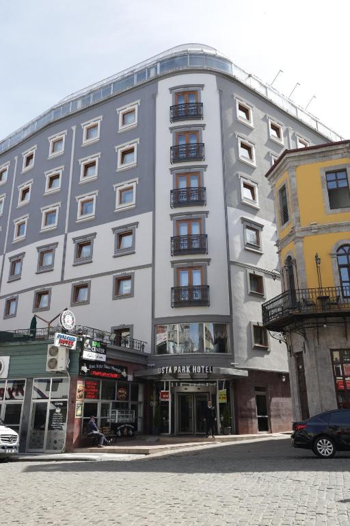 un grand bâtiment gris dans une rue de la ville dans l'établissement Usta Park Hotel, à Trabzon