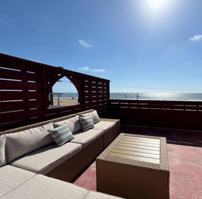 um sofá sentado numa varanda com vista para a praia em Oceanfront Condo with Private Deck & Endless Views em Los Angeles