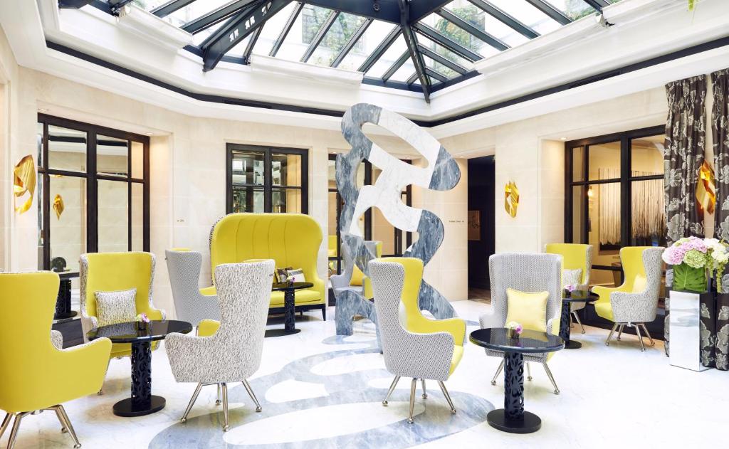 パリにあるル ブルガンディ パリの椅子とテーブル、彫刻が備わる部屋