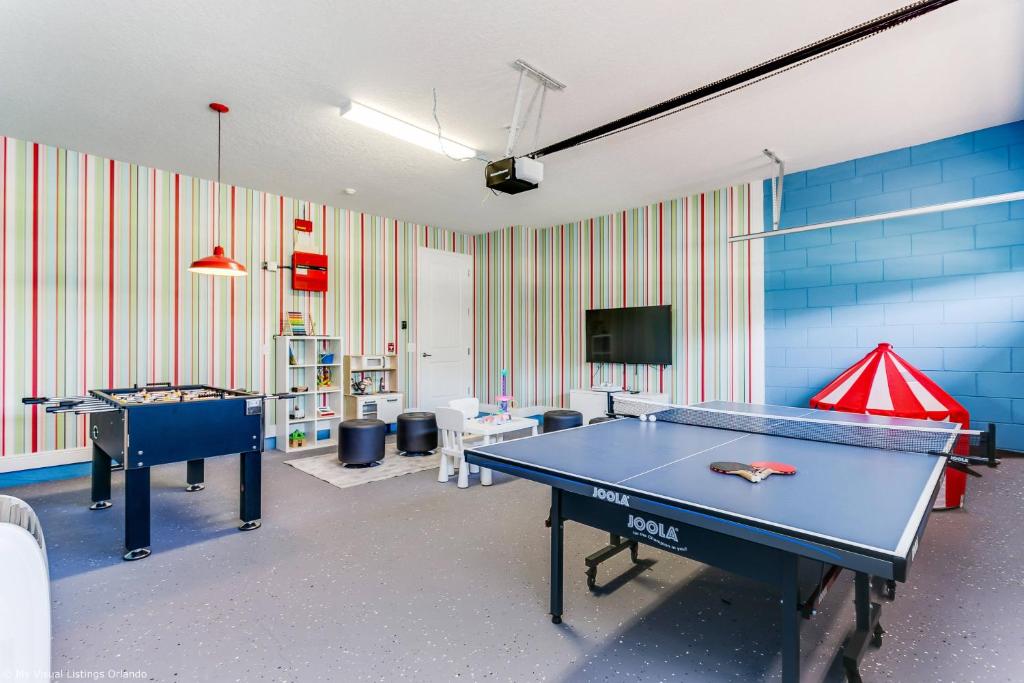 Cette chambre dispose de 2 tables de ping-pong et d'une télévision. dans l'établissement 8 Bedroom Vacation Home with Pool 2114, à Orlando