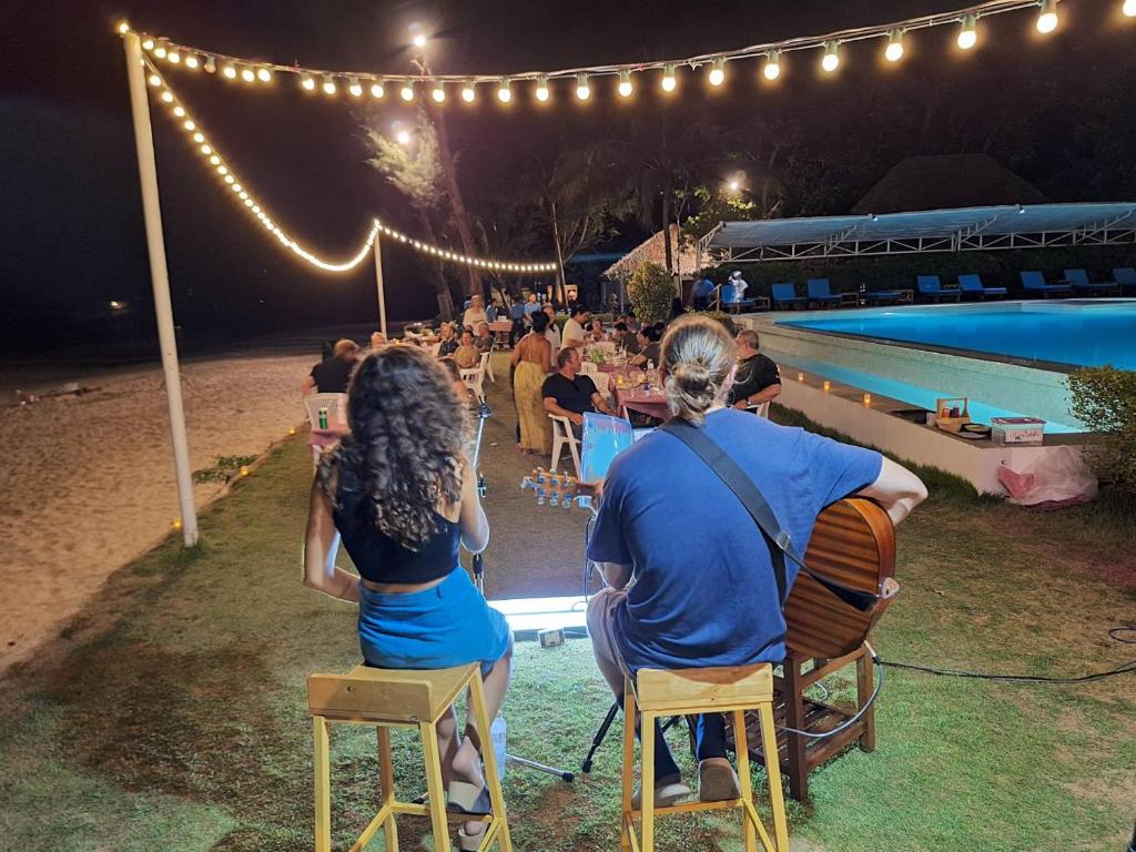 eine Gruppe von Personen, die an einem Pool auf Stühlen sitzen in der Unterkunft Twin Bay Resort Koh Lanta in Ko Lanta