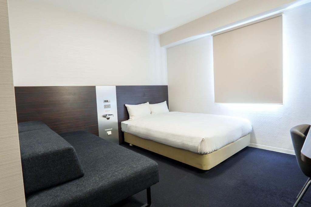 Postel nebo postele na pokoji v ubytování Osaka City Hotel Kyobashi