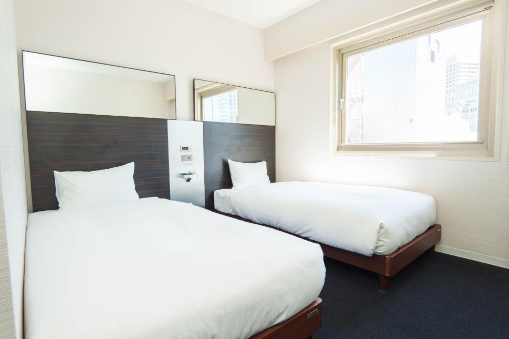 Postel nebo postele na pokoji v ubytování Osaka City Hotel Kyobashi