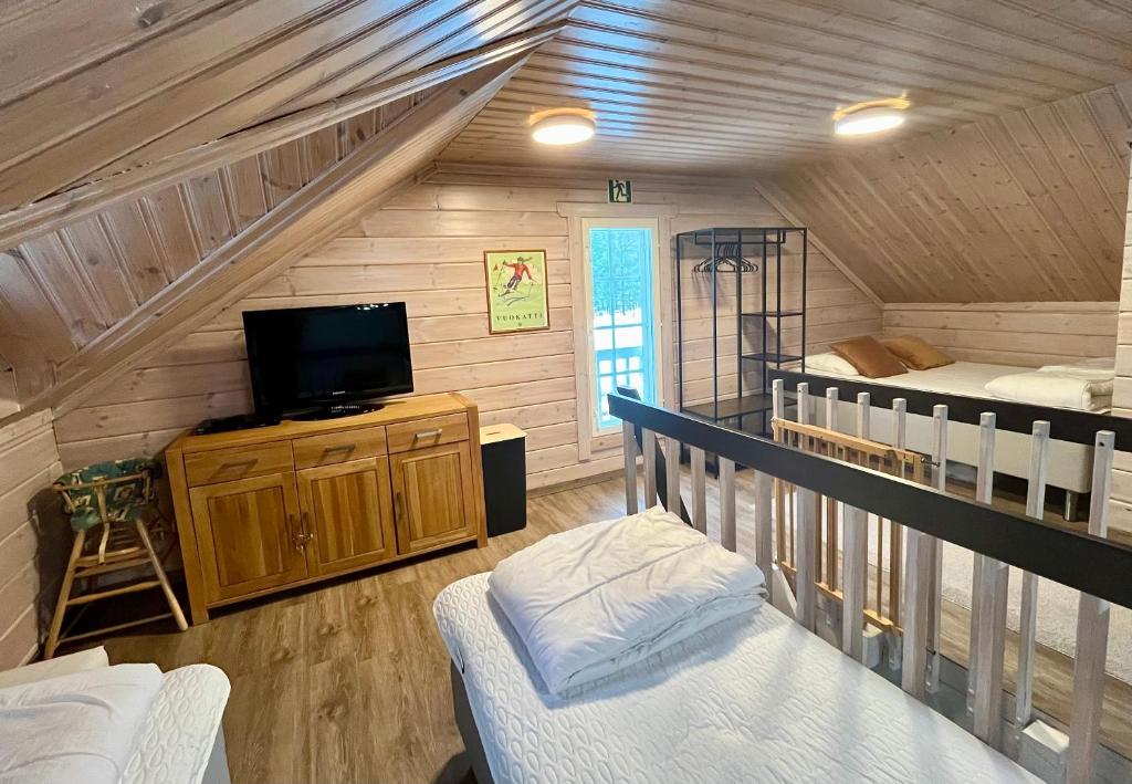 eine Hütte mit einem TV und einem Etagenbett in der Unterkunft Vuokatti Weekend Lux in Vuokatti