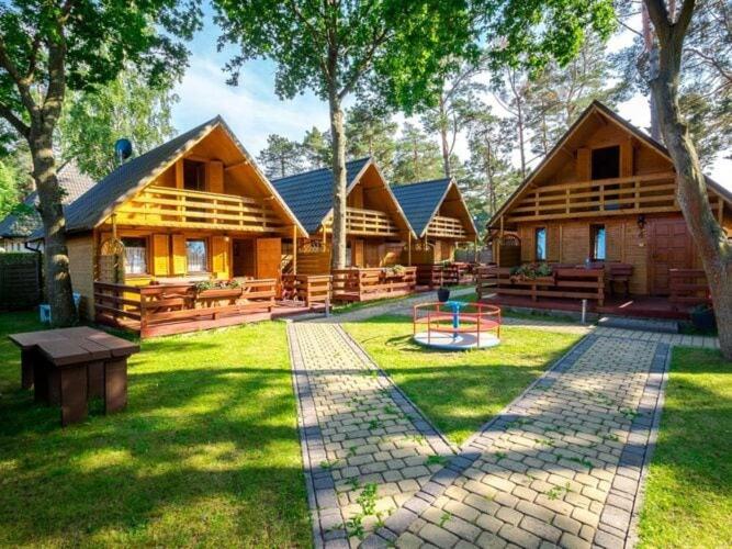 a large log cabin with a patio in the yard at Holiday house for 5 people, Jaros awiec in Jarosławiec