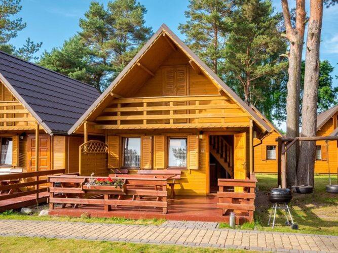 a wooden house with a picnic table in front of it at Holiday house for 4 people, Jaros awiec in Jarosławiec
