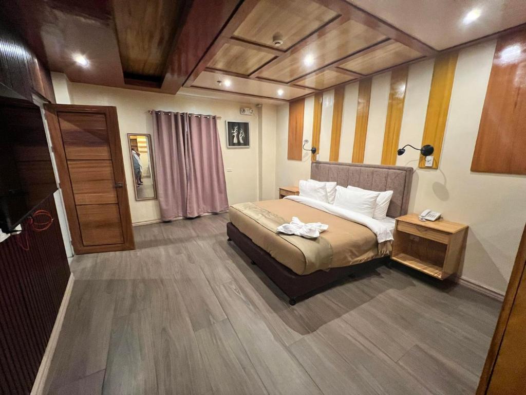 Un dormitorio con una cama y una mesa con toallas. en Raim Hotel en Pagadían​