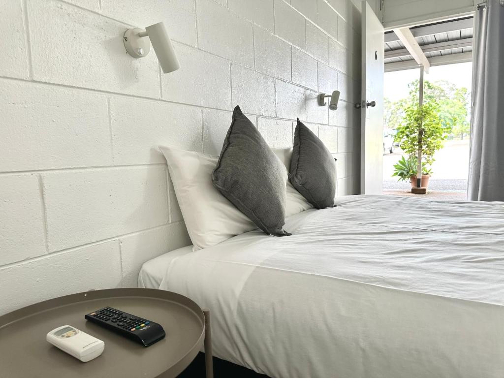 un letto bianco con telecomando su un tavolo di Sawmill Hotel Motel a Wondai