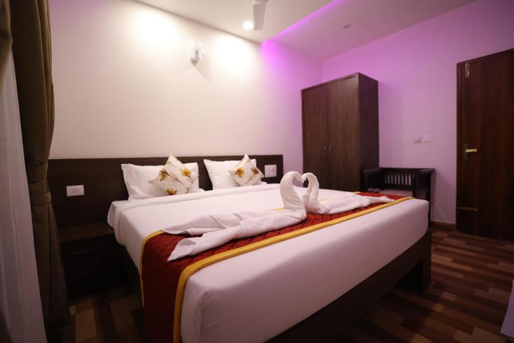 a bedroom with a bed with towels on it at Valley Plaza Hotel Coorg in Madikeri