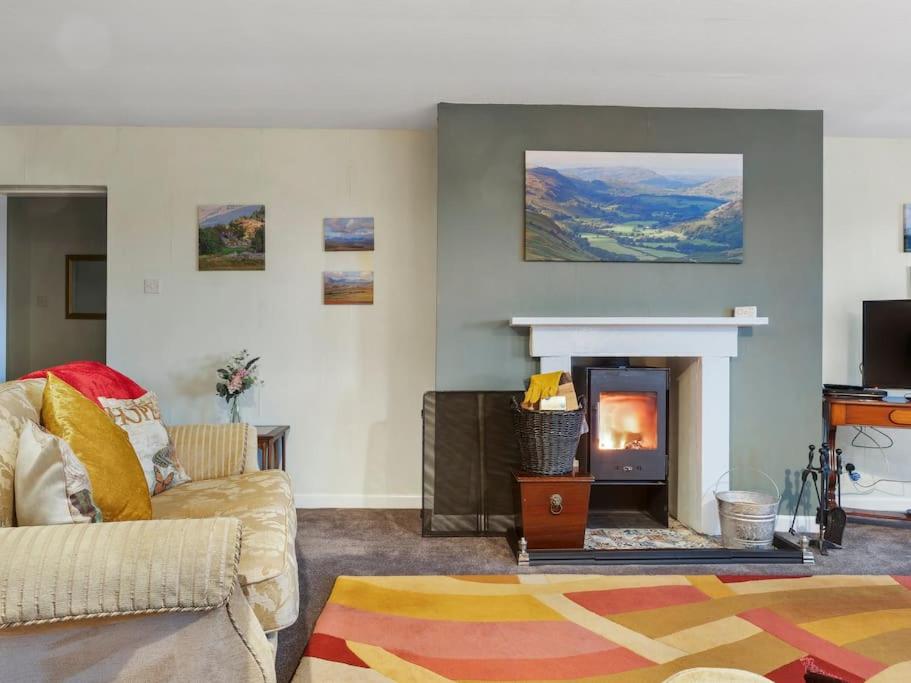 a living room with a couch and a fireplace at Miterdale A Wonderful Home in the Idyllic Duddon Valley in Broughton in Furness