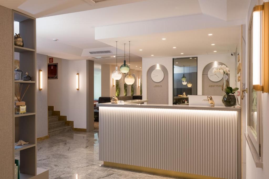 a lobby with a counter and a living room at Hotel Marco Polo in Lido di Jesolo