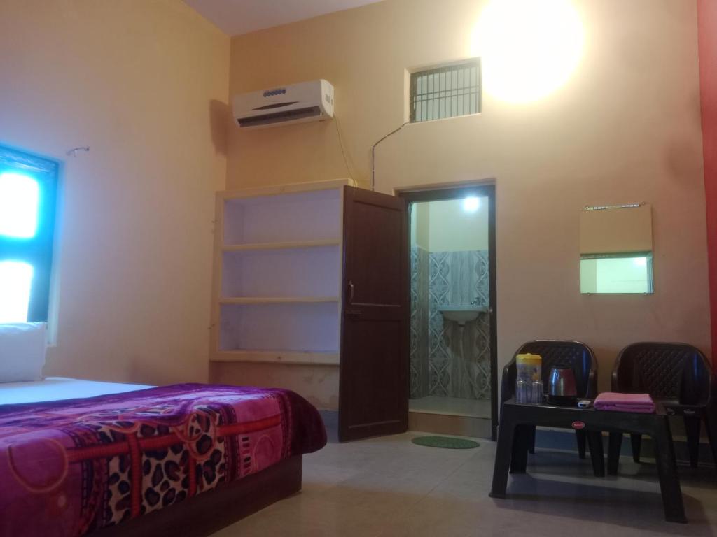 - une chambre avec un lit, un placard et une porte dans l'établissement Aanand Bhwan, à Ayodhya