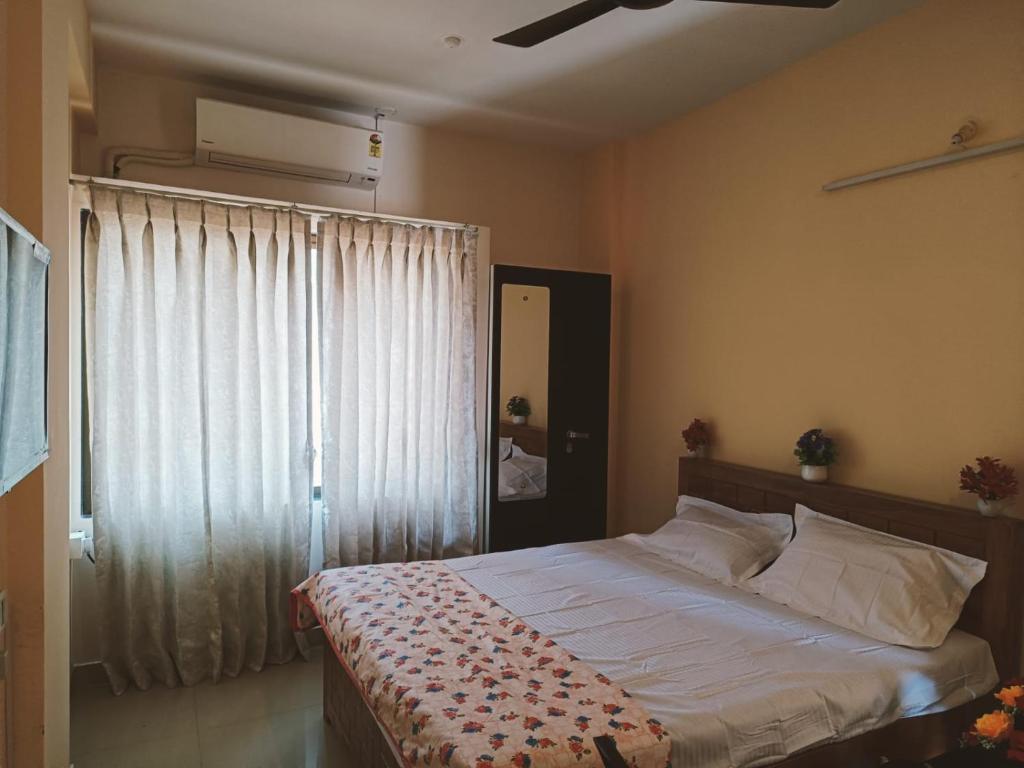 sypialnia z dużym łóżkiem i oknem w obiekcie Great Hornbill Homestay, Ratnagiri w mieście Ratnagiri