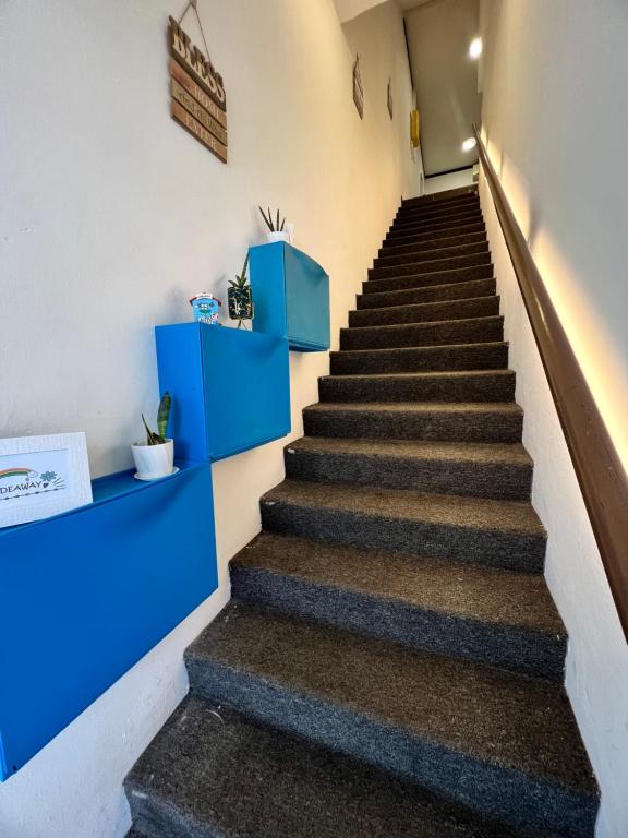 un escalier dans un bâtiment avec des étagères bleues dans l'établissement Hideaway ~ Best Memories start here!, à Mersing