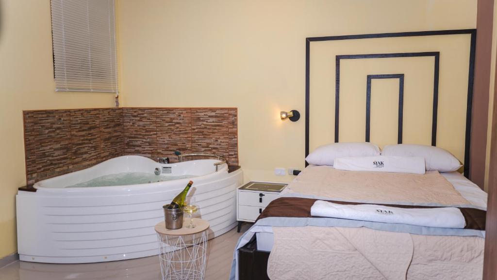 皮烏拉的住宿－Mak Suites，带浴缸、床和盥洗盆的浴室