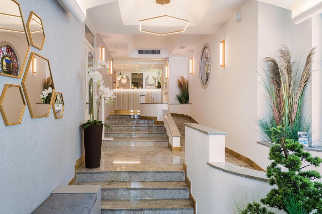 a hallway with stairs and plants in a building at Hotel Marco Polo in Lido di Jesolo